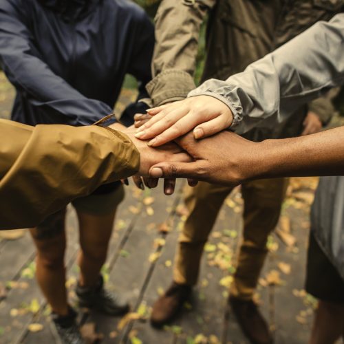 Group of hikers stacking hands